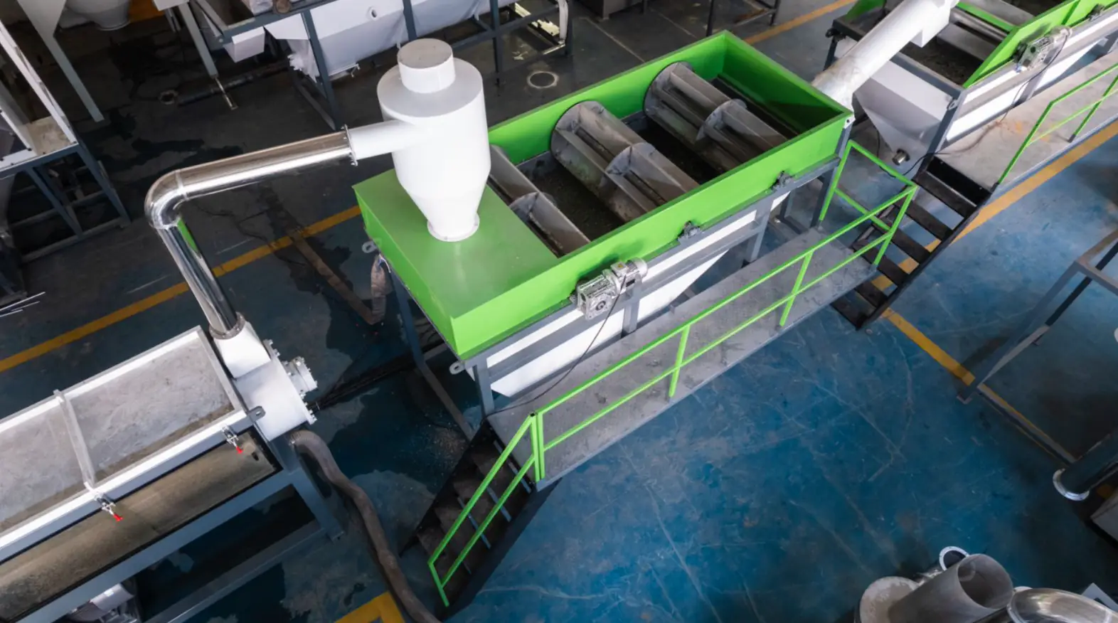 Cold washing stages remove loose dirt, beverage residue and floating caps with water and mechanical action. Cold washing tank with rollers in a PET bottle washing line