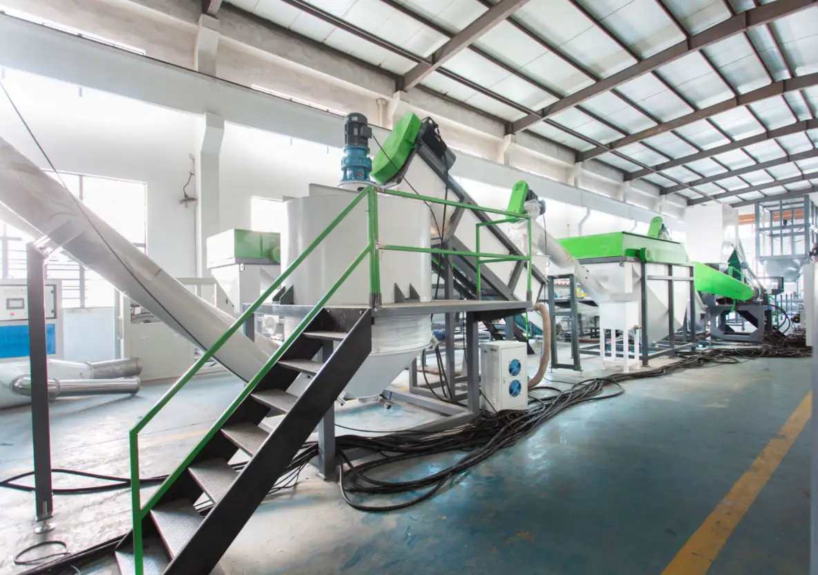 The hot-wash section combines heat, residence time, agitation and chemical dosing to loosen glue and oil. Hot washer and friction washing section of a PET bottle washing line in a factory