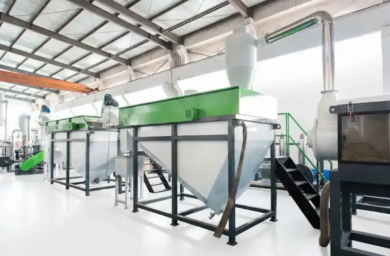 PET bottle washing line in a factory with washing tanks, screw conveyors and a cyclone